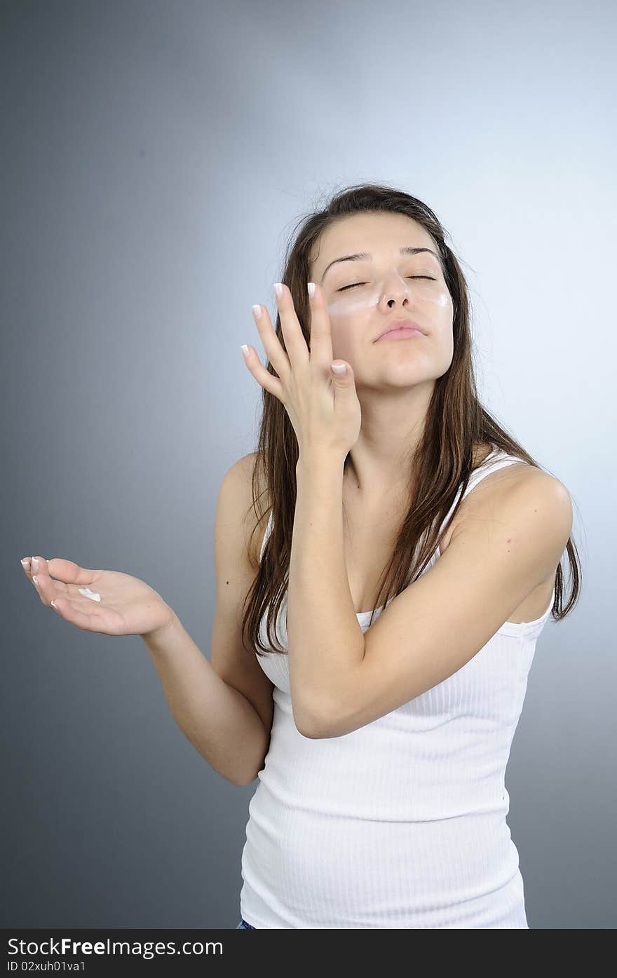 White adult treating her face. White adult treating her face