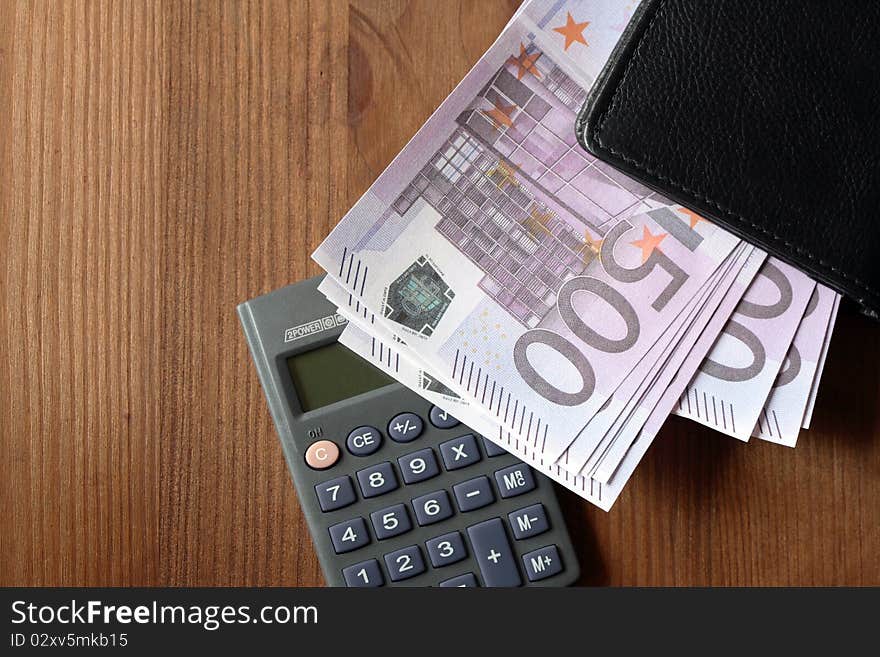 European union currency and calculator on wooden background. European union currency and calculator on wooden background