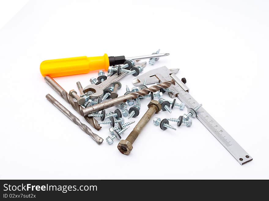 Building,metalworking instruments, and screws on white background