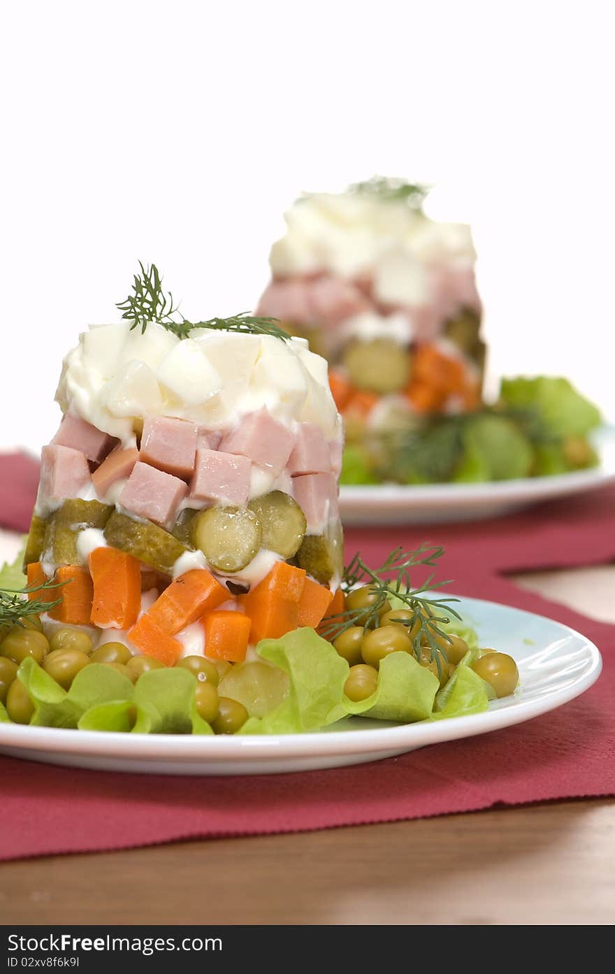 Two plates with salad on a white background. Two plates with salad on a white background