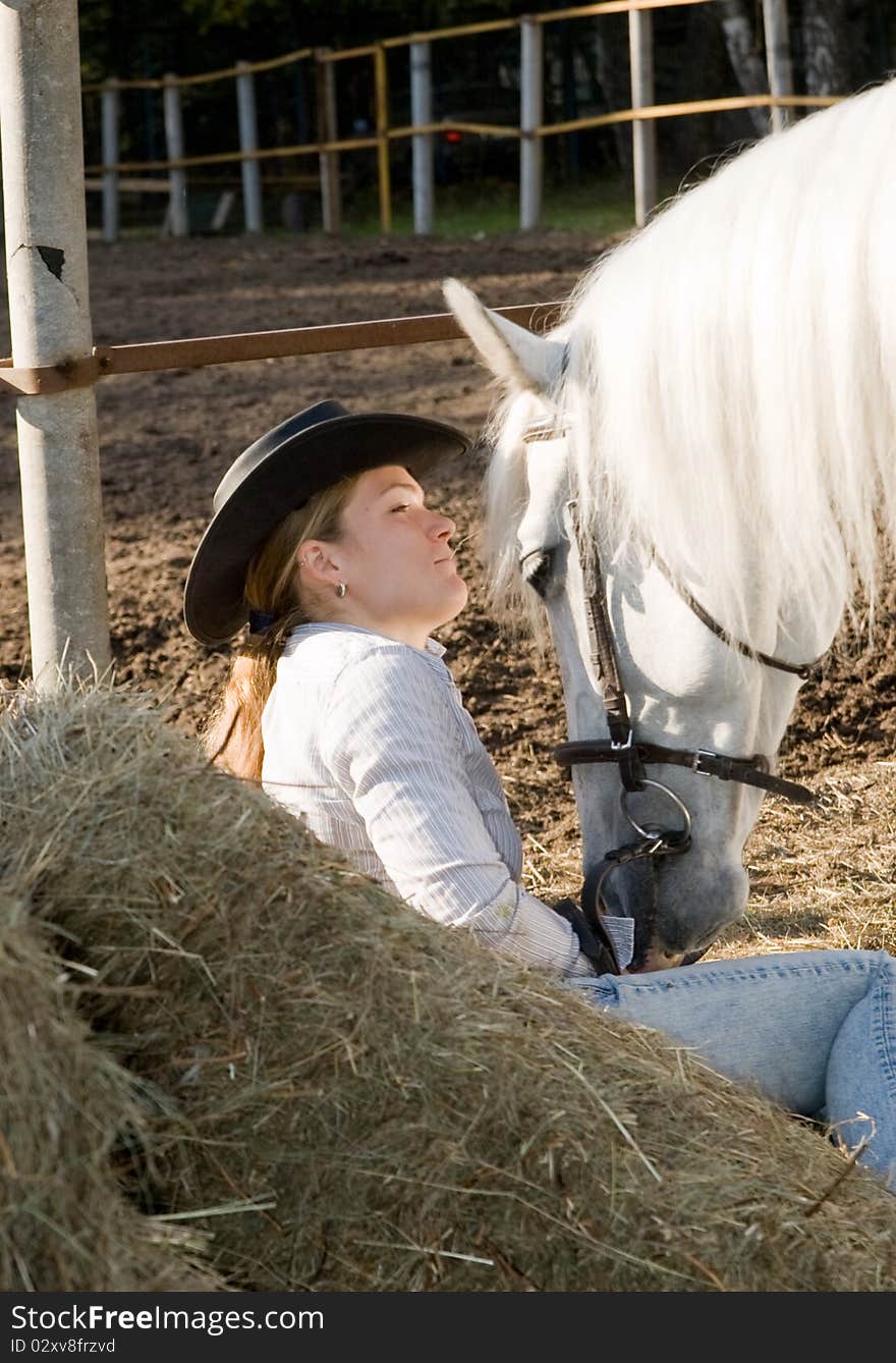 Portrait of young woman with her white horse on the farm yard. Portrait of young woman with her white horse on the farm yard