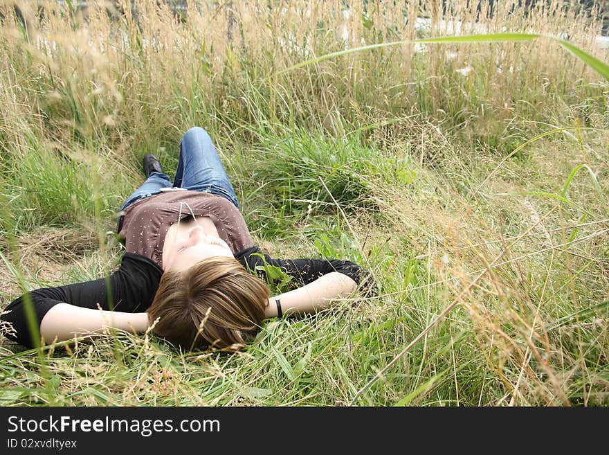 Young woman is relaxing in the grass