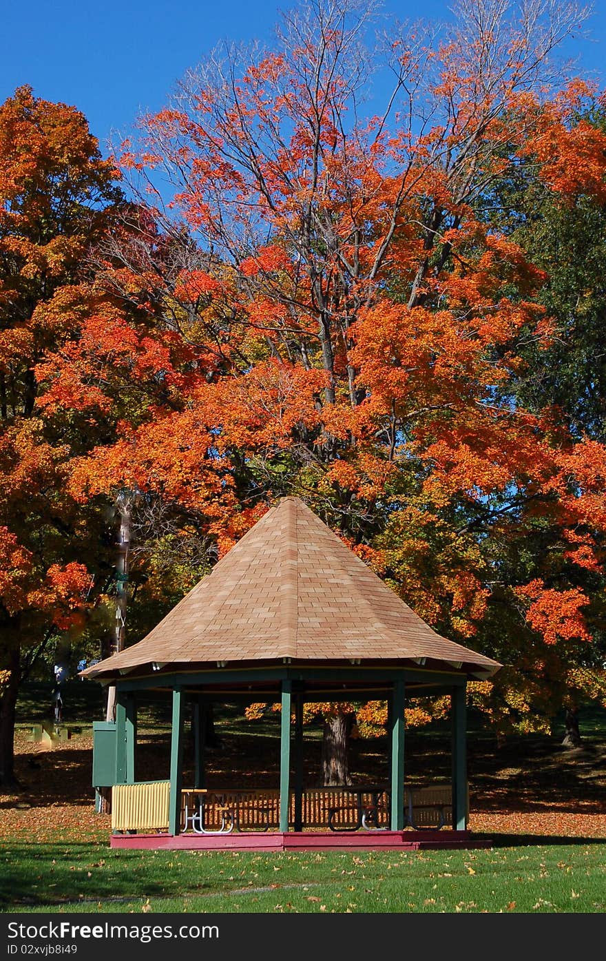 The gazebo is located in a park and is surrounded by beautiful autumn colors. The gazebo is located in a park and is surrounded by beautiful autumn colors.