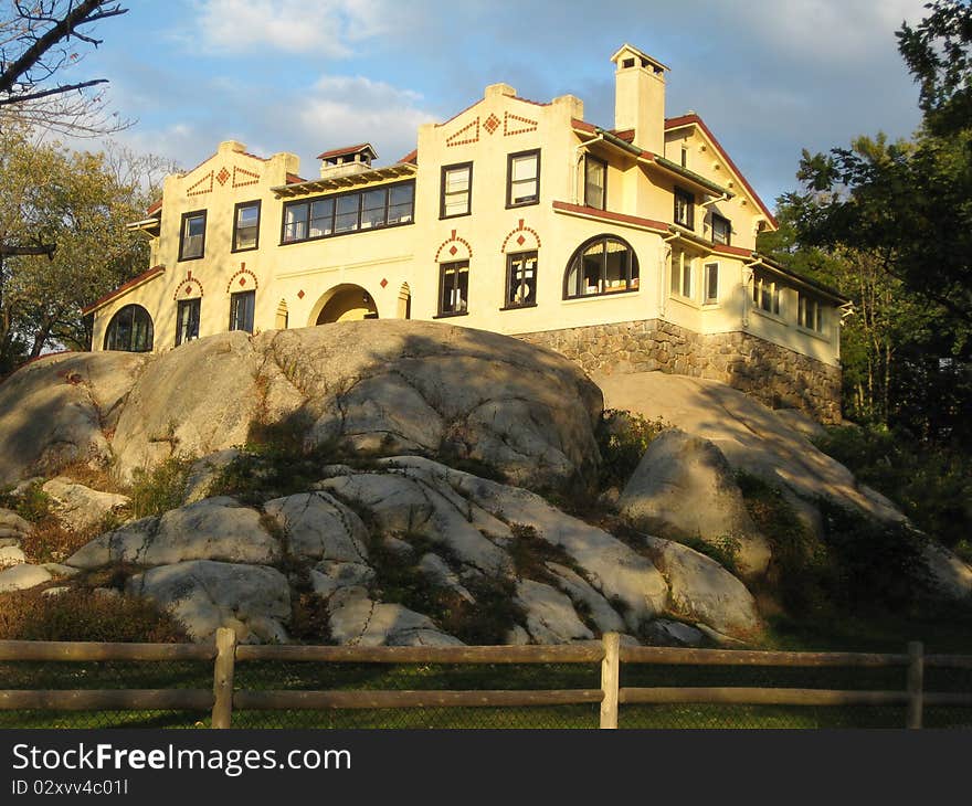 A beautiful building sits high on the rocks in the afternoon sunshine.