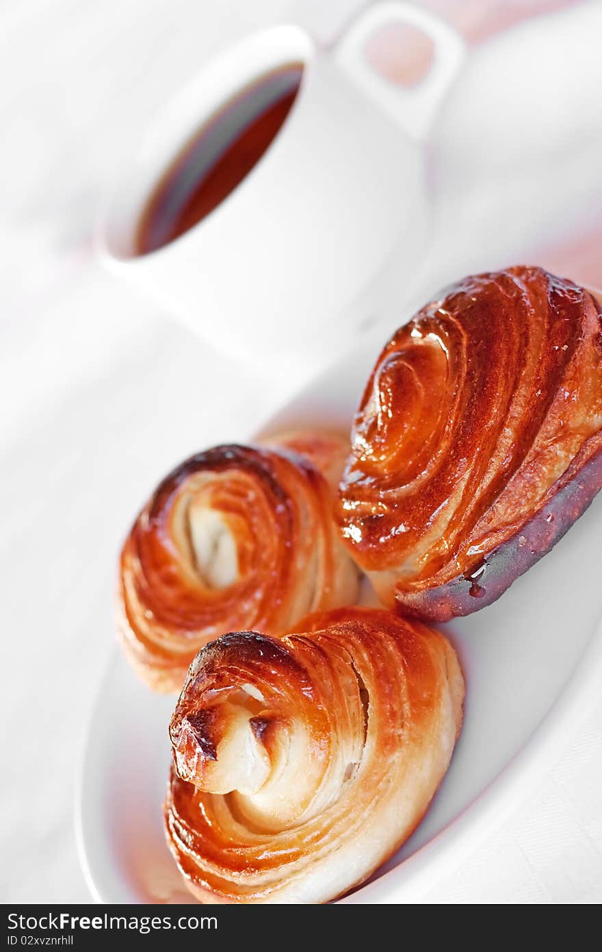 Strong tea with fresh croissants on a plate. Strong tea with fresh croissants on a plate