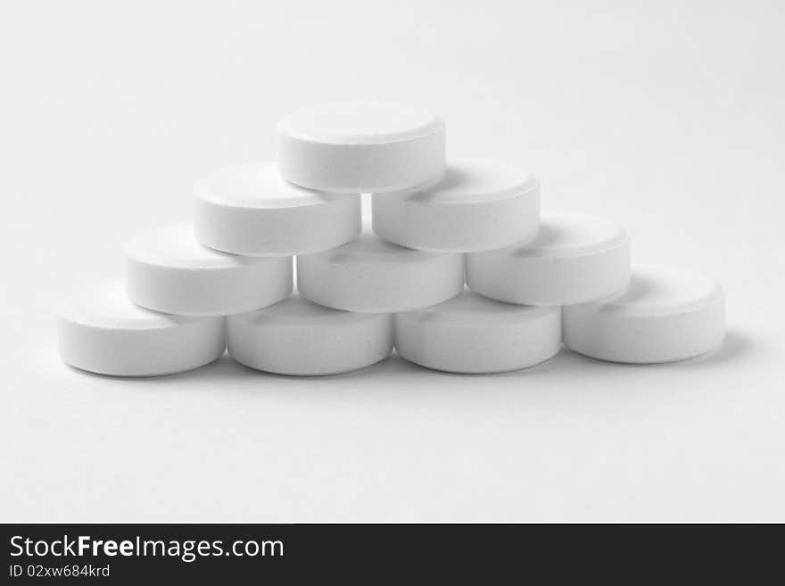 Pile of round pills on gray surface. Pile of round pills on gray surface