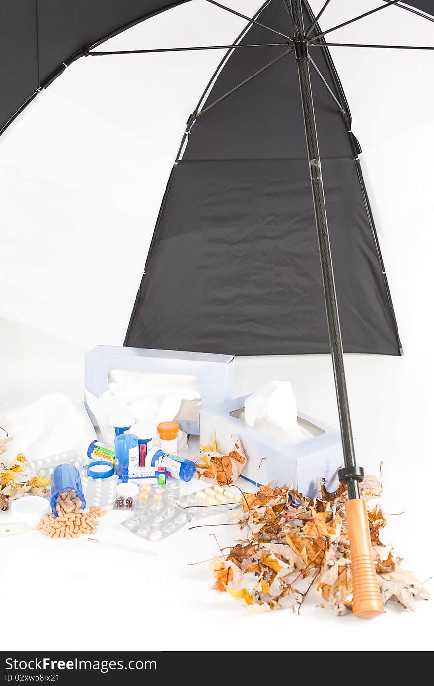 A studio front portrait orientation concept shot of the cold and flu season showing various cold medicines, tissue boxes,thermometers, umbrella and fall leaves. A studio front portrait orientation concept shot of the cold and flu season showing various cold medicines, tissue boxes,thermometers, umbrella and fall leaves.