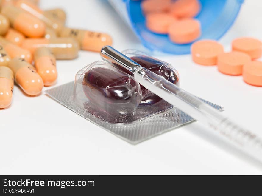 A studio macro concept shot of the cold and flu season showing various cold medicines, and a basil thermometer. A studio macro concept shot of the cold and flu season showing various cold medicines, and a basil thermometer.