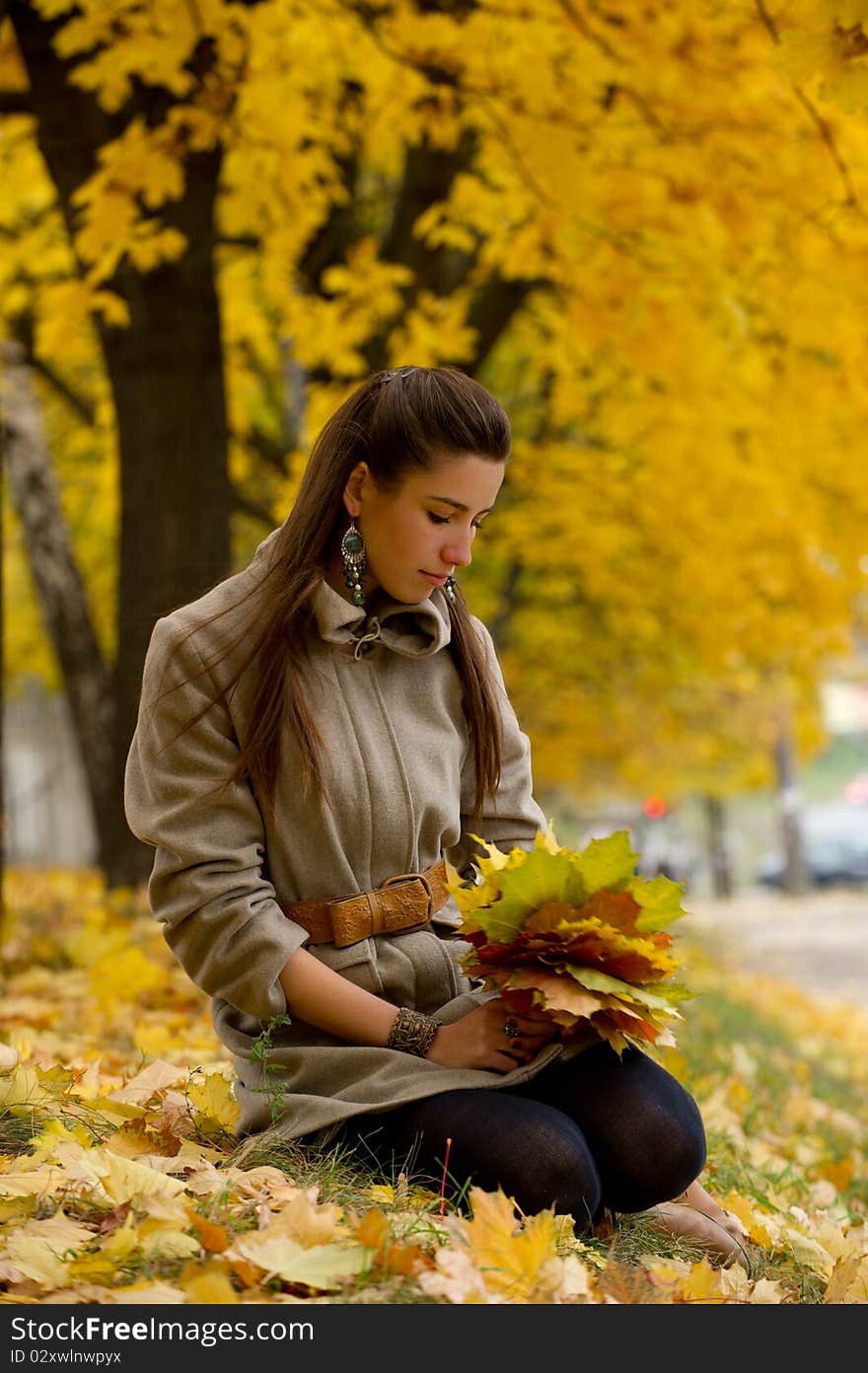 Young girl longs in the autumn in park