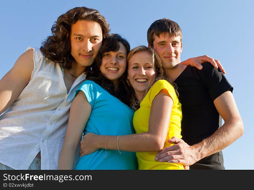 Young people, two girls and two boys, hugged each other and smile