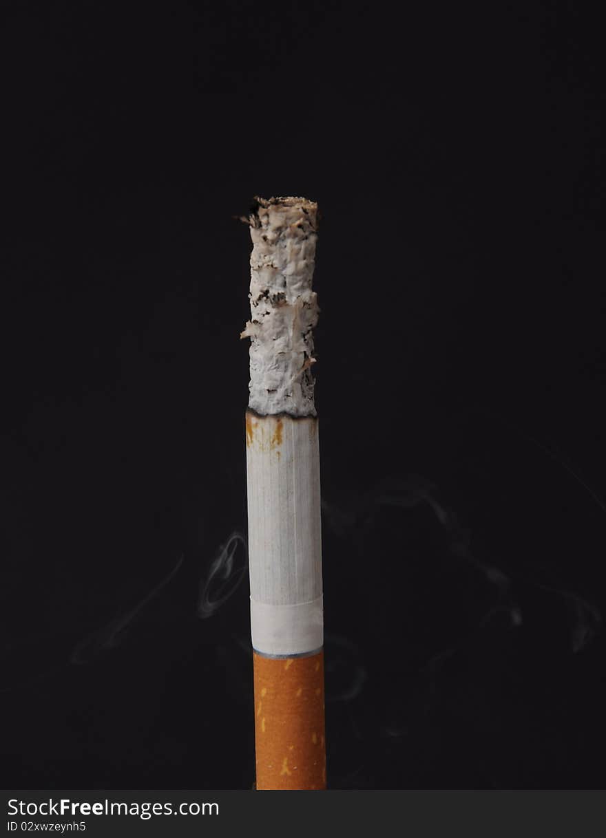 Lit cigarette on a black background