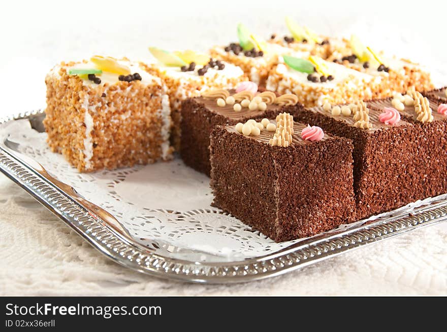 Variety of miniature cakes on a silver platter. Variety of miniature cakes on a silver platter