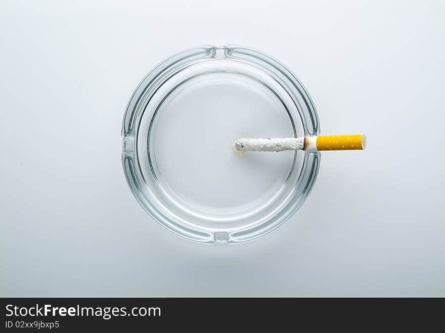 Cigarette in a ashtry made of glass. Cigarette in a ashtry made of glass