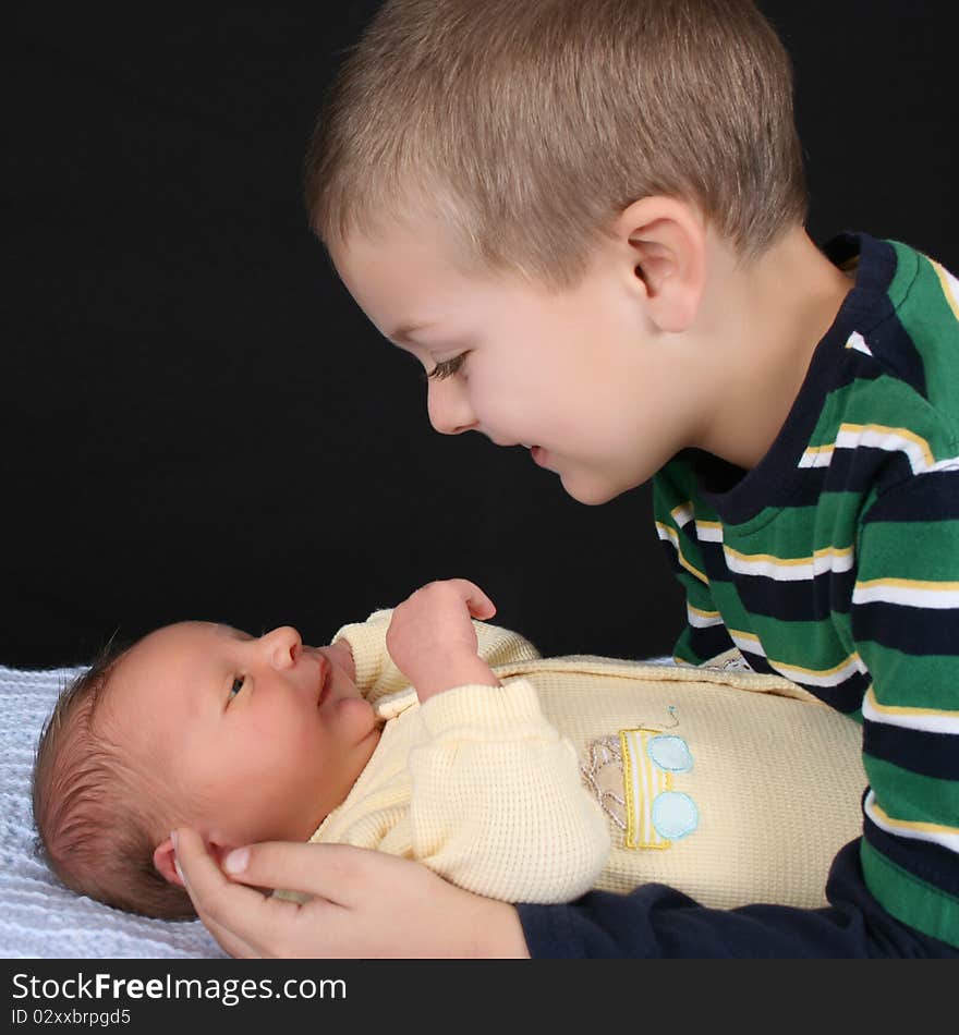 Blond boy with his newborn baby brother. Blond boy with his newborn baby brother