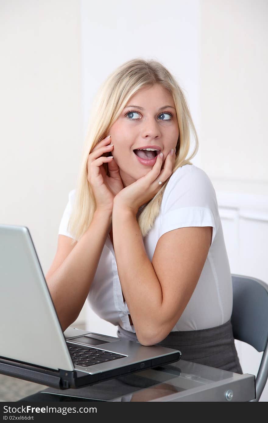 Blond businesswoman doing funny faces in the office. Blond businesswoman doing funny faces in the office