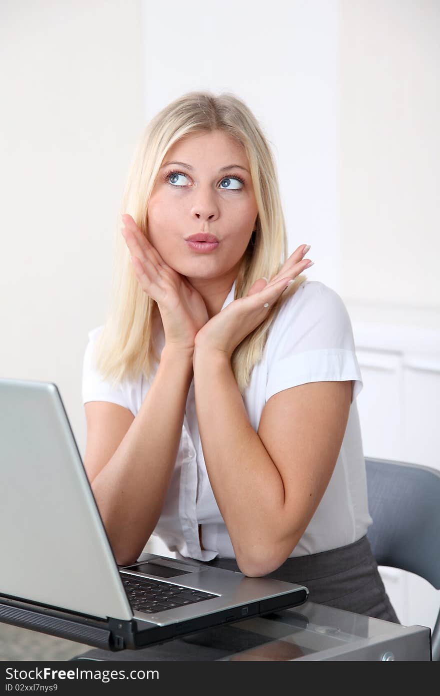 Blond businesswoman doing funny faces in the office. Blond businesswoman doing funny faces in the office