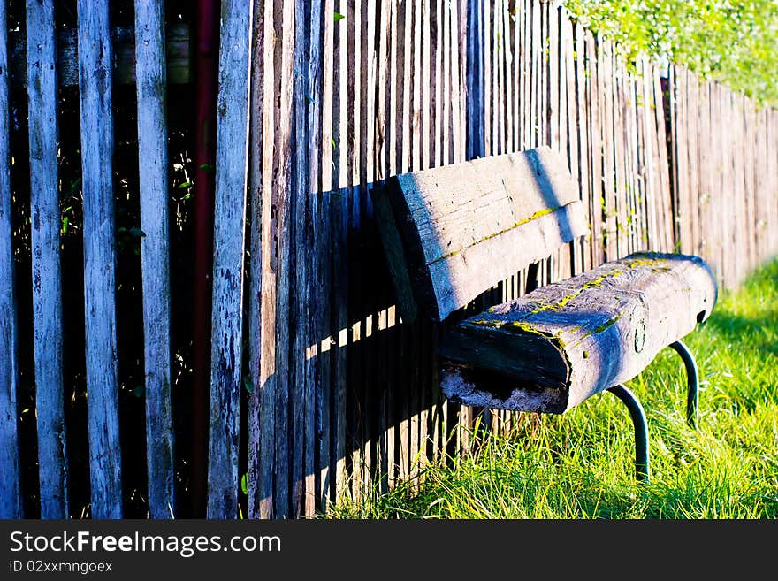 Old wooden boundary fence with nails on sunny day