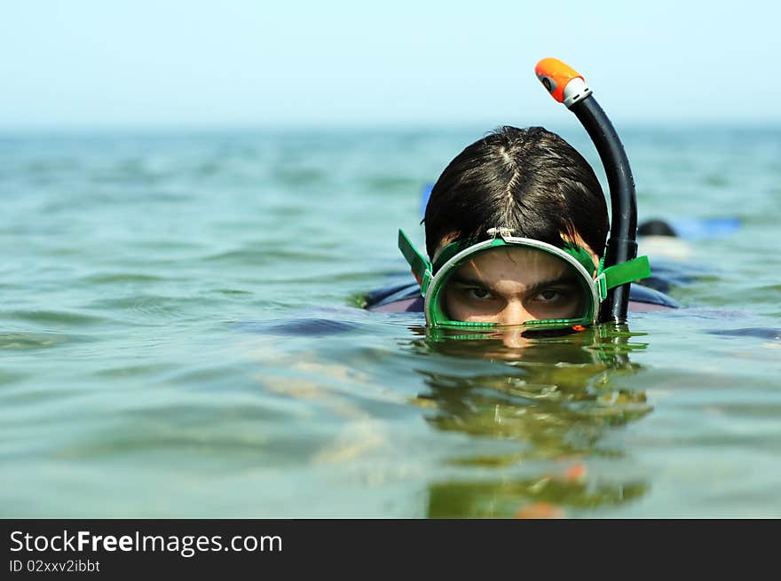 The young guy plunges under water with swimming equipment. Diving. The young guy plunges under water with swimming equipment. Diving.