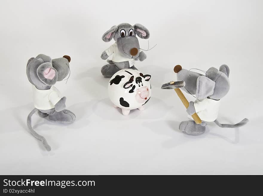 This image shows three soft toys with a hammer to break a piggy bank. This image shows three soft toys with a hammer to break a piggy bank