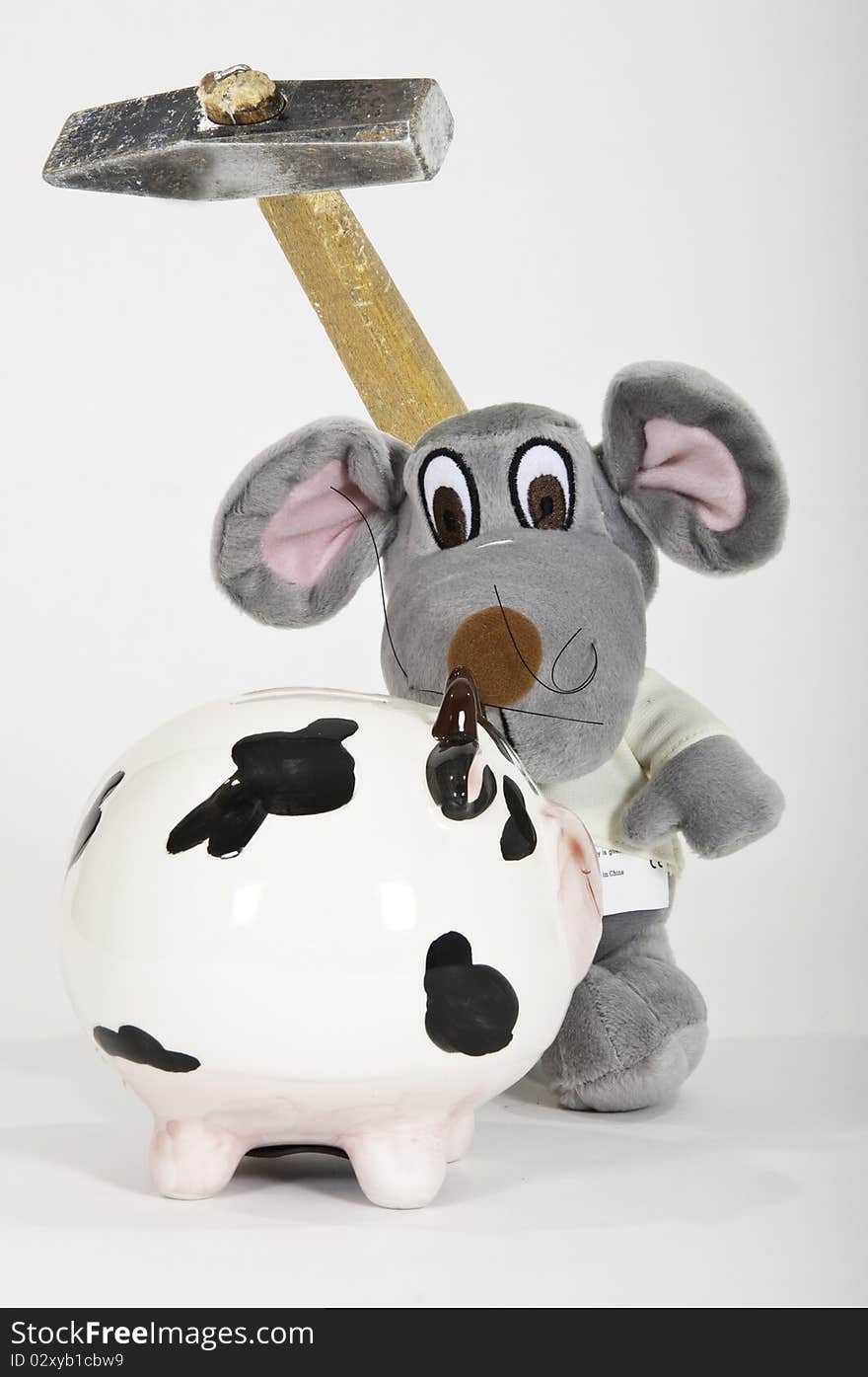 This image shows a soft toy with a hammer to break a piggy bank. This image shows a soft toy with a hammer to break a piggy bank
