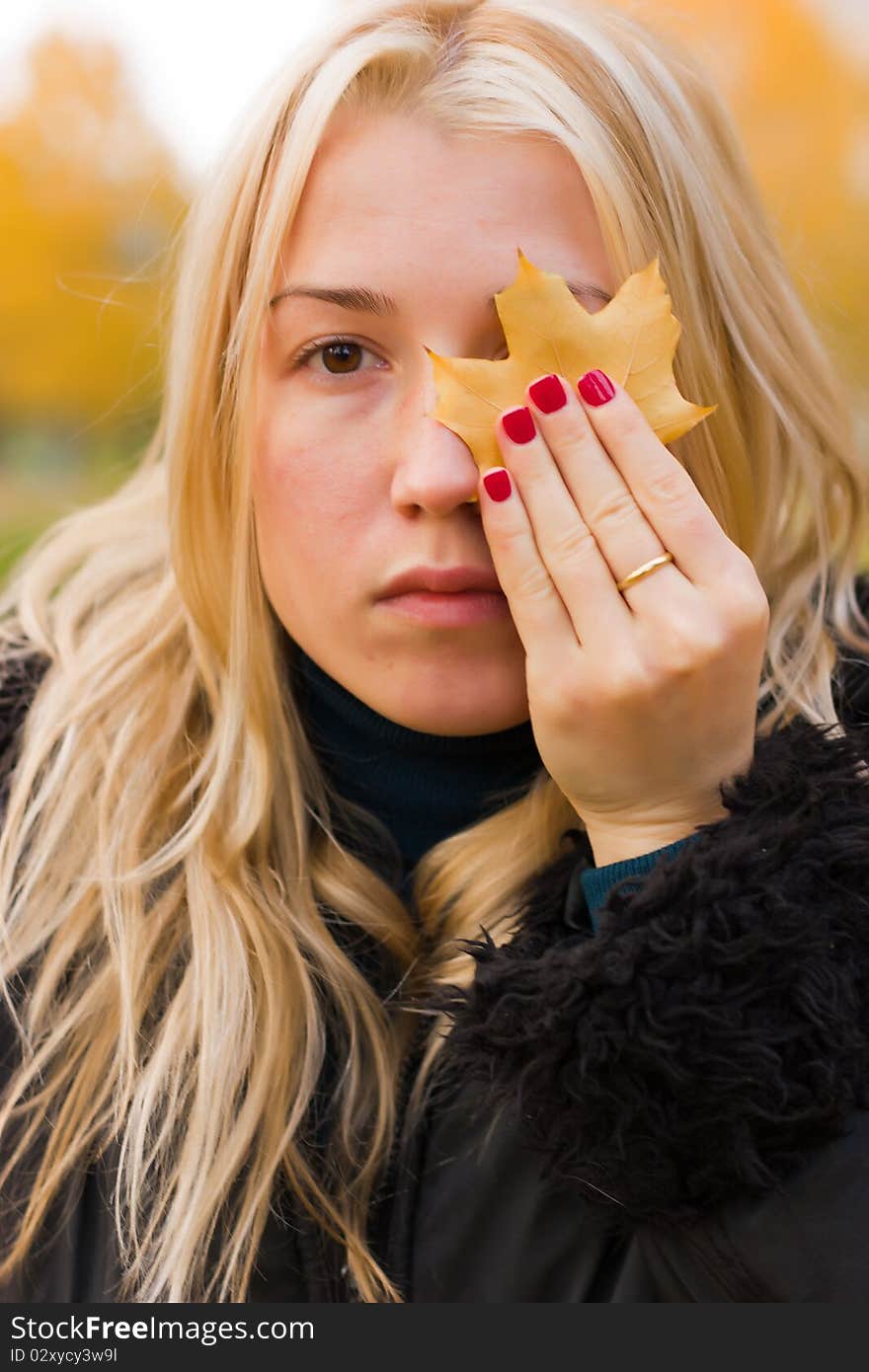 Beautiful young woman close up against autumn background. Beautiful young woman close up against autumn background