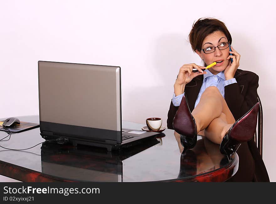 Attractive secretary sitting and talking on cell phone