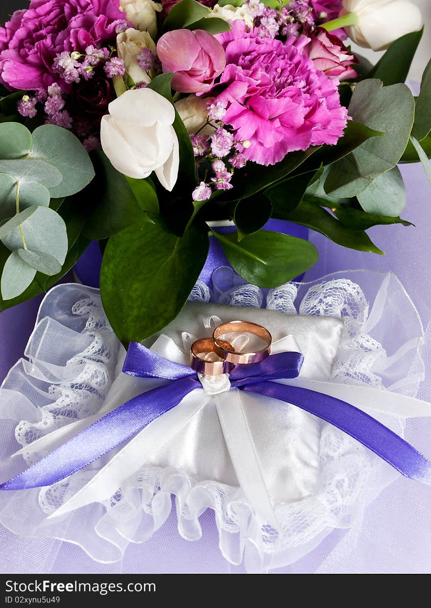 Closeup of wedding rings with a bouquet