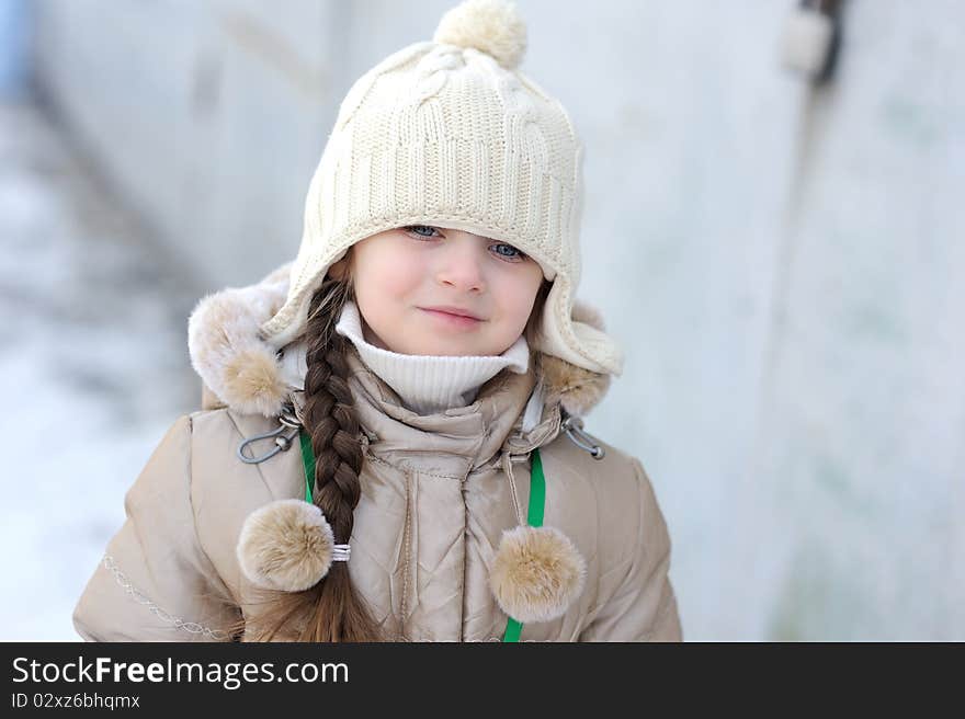 Adorable winter small girl in whitr warm hat and jacket i