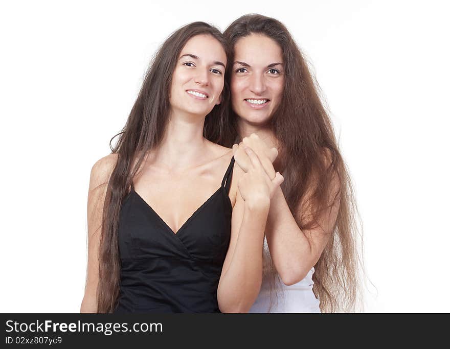 Two sisters with very long brown hair standing smiling - isolated on white. Two sisters with very long brown hair standing smiling - isolated on white