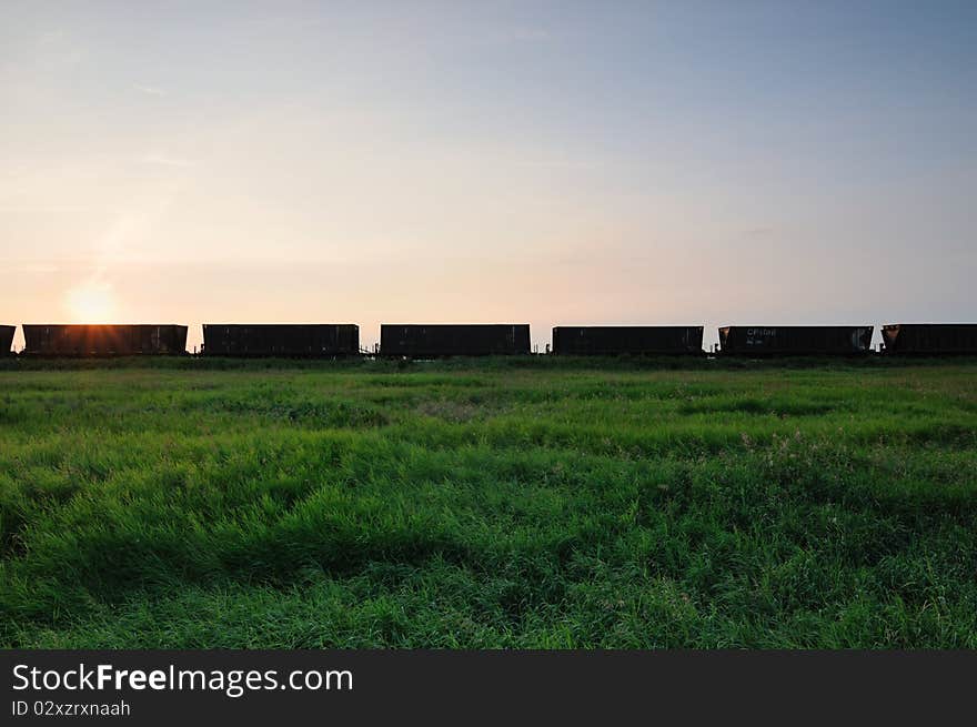 Railroad grain cars in the prairies with blue sky