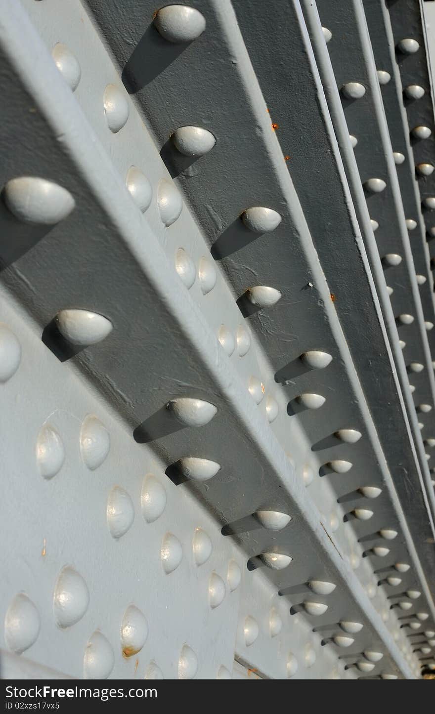 Steel construction fastened with rivets - industrial background. Shallow depth of field