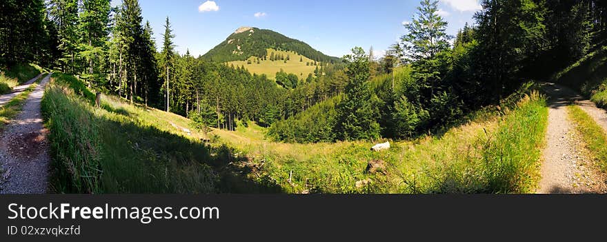 The peak of the mountain Hochstafl in the Reisalpe region in Lower Austria with a gravel road in the foreground. The peak of the mountain Hochstafl in the Reisalpe region in Lower Austria with a gravel road in the foreground