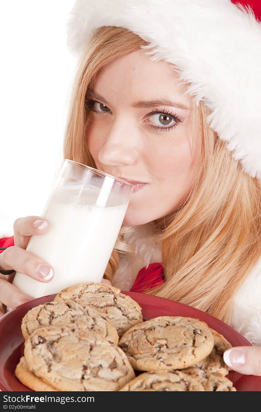 A close up shot of Mrs Santa drinking milk and holding cookies. A close up shot of Mrs Santa drinking milk and holding cookies.