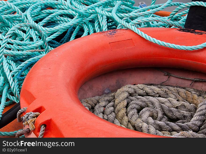 An orange lifebelt and blue rope on the wheelhouse of a fishing vessel in The Barbican harbour, Plymouth, Devon, UK. An orange lifebelt and blue rope on the wheelhouse of a fishing vessel in The Barbican harbour, Plymouth, Devon, UK