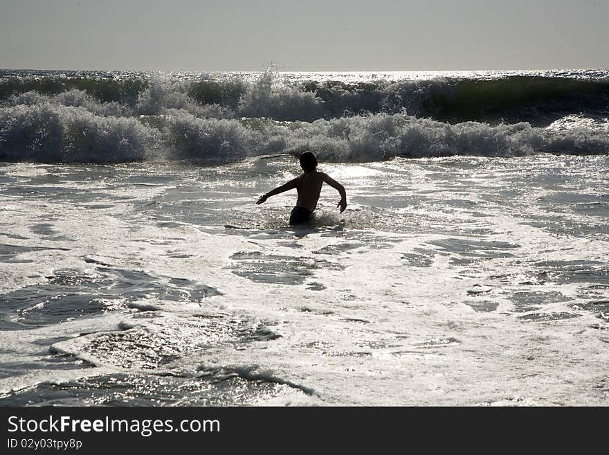 Swimmer in silver light at sunset at Redondo Beach, California