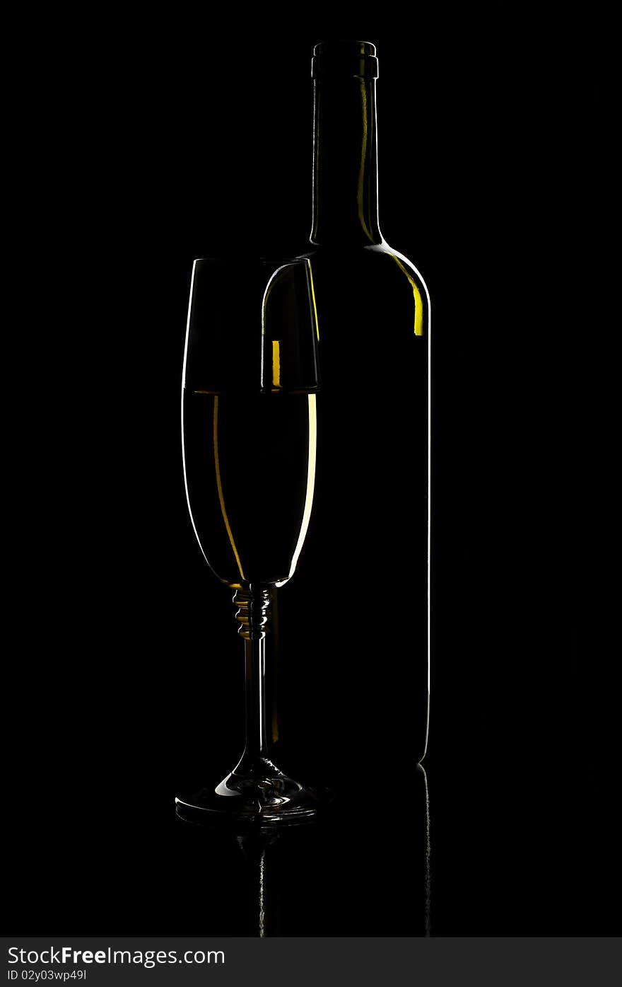 Glass of wine and bottle on black background