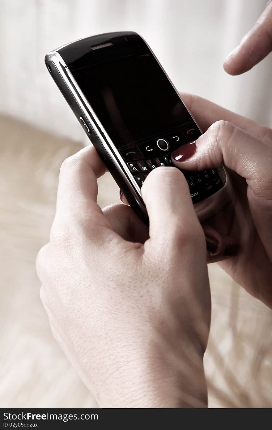 Hands of a woman operating a mobile phone. Hands of a woman operating a mobile phone