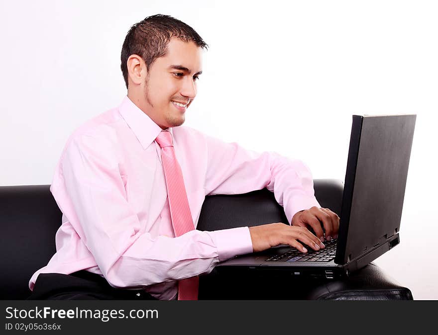 Young businessman typing on laptop. White background