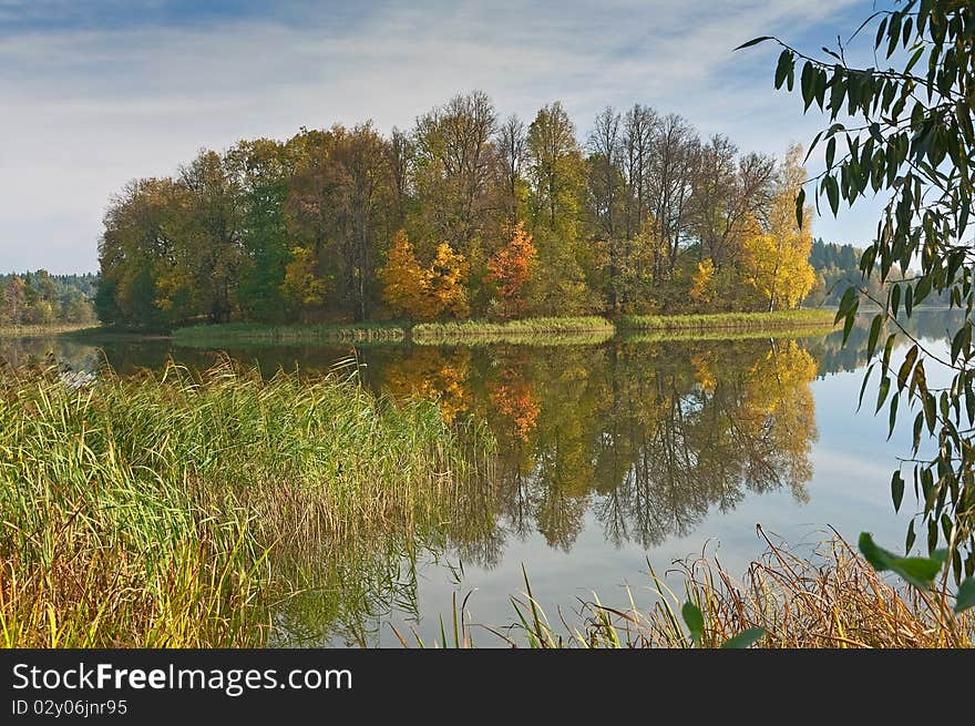 Autumn island with reflexion in water