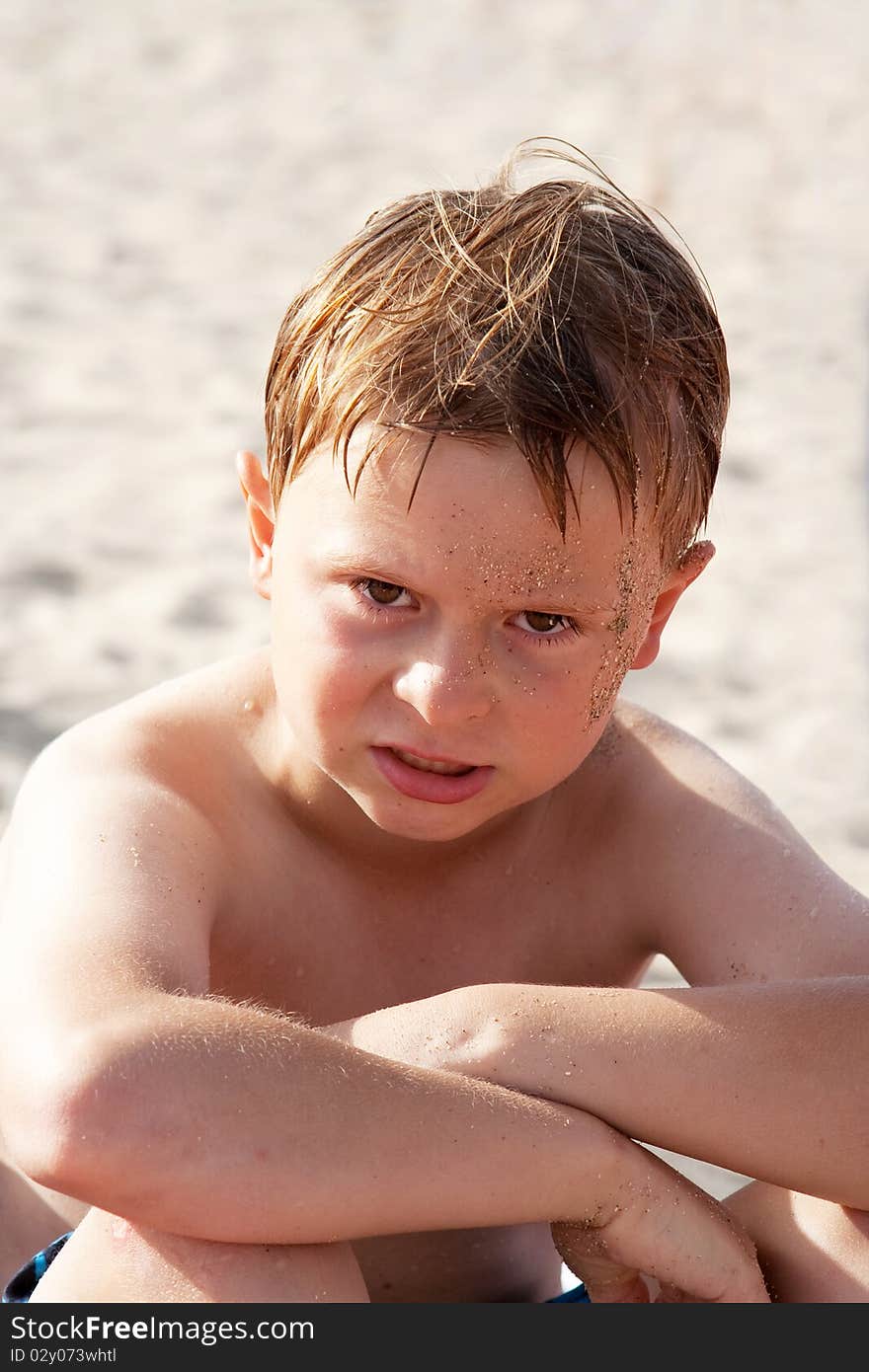 Child, boy at the beach is angry and his face looks annoyed. Child, boy at the beach is angry and his face looks annoyed