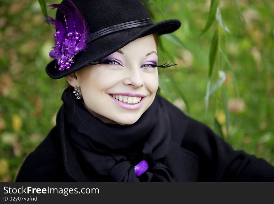 The image of a beautiful girl in a purple dress in the autumn park. The image of a beautiful girl in a purple dress in the autumn park