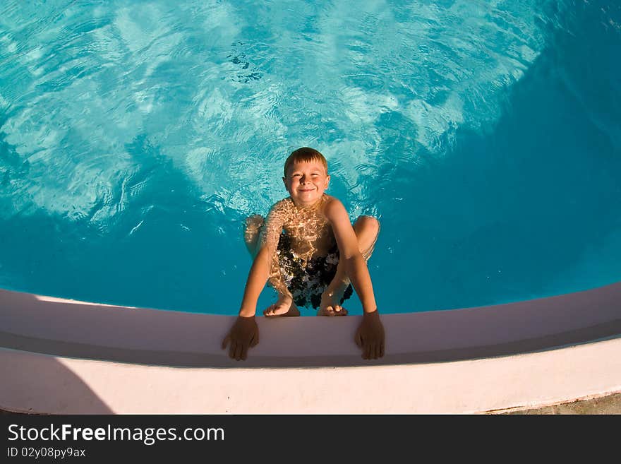 Child is posing in the pool and makes fun