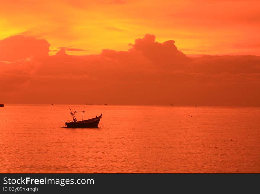 Slow boat on the sea an orange sky. Slow boat on the sea an orange sky