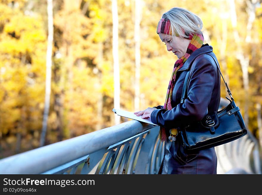 Young woman with book in autumn park