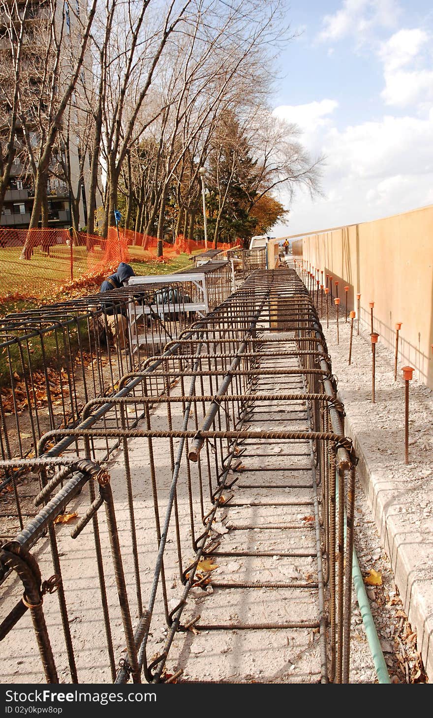 Some construction workers building a new and higher wall on the lake to prevent damages from high waves front lake Ontario. Some construction workers building a new and higher wall on the lake to prevent damages from high waves front lake Ontario.