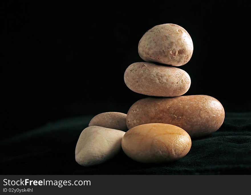 Arrangement with pebbles on dark background, a still life. Arrangement with pebbles on dark background, a still life