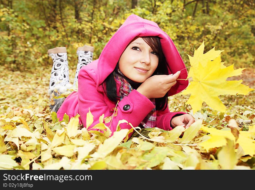 Girl at the hood lies on the yellow the foliage. Girl at the hood lies on the yellow the foliage