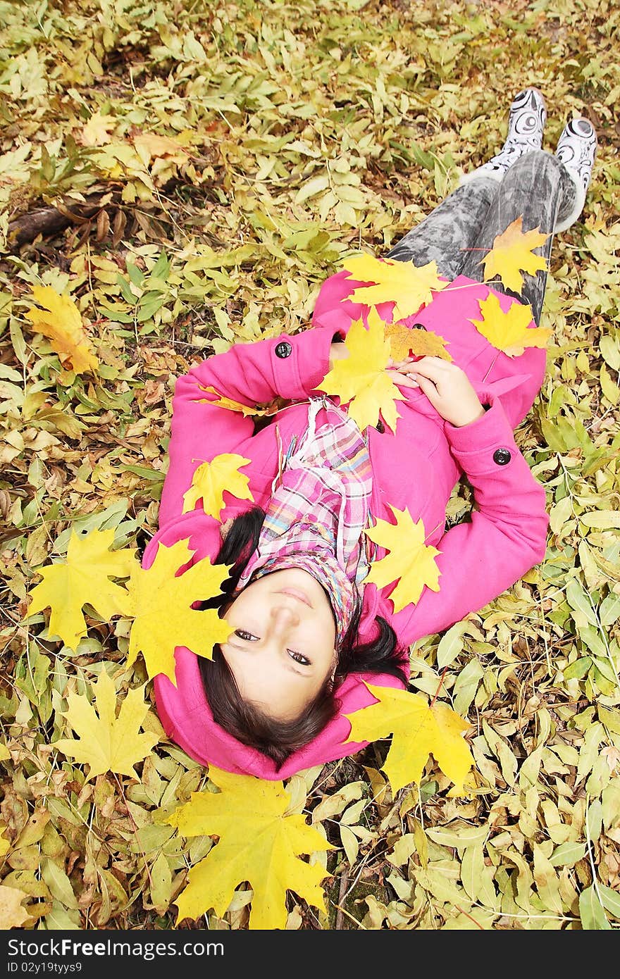 Girl lies on the spin on the foliage. Girl lies on the spin on the foliage