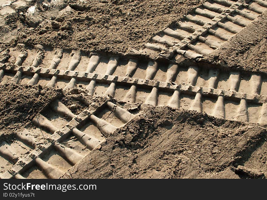 Bulldozer footprints intersect on soil