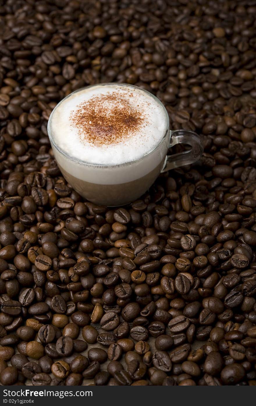 Cup of cappuccino and coffee beans